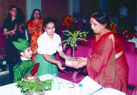 A student being presented a sapling