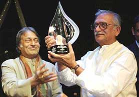 Lyricist Gulzar receives a lifetime achievement award from Sarod maestro Ustad Amjad Ali Khan at a function "Ek Shaam Gulzar Ke Naam" in New York on Sunday evening. 