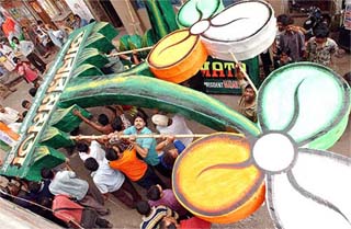 Trinamool activists carry a huge model of the party symbol in a Kolkata street on Tuesday. 