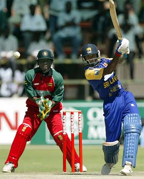 Upul Chandana drives a delivery watched by Zimbabwean wicketkeeper Tatenda Taibu 