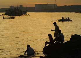Residents play on the seashore in the southern Philippine city of Zamboanga on Thursday