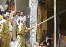 A fireman tries to control the fire at a crackers shop at Street No. 11, Field Gunj, in Ludhiana