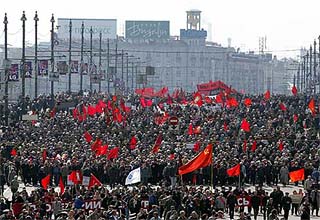 Russian Communists carrying red flags march across the bridge