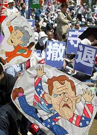 Placards of US President George W. Bush and Japanese Prime Minister Junichiro Koizumi are displayed in protest against US and Japanese troops presence in Iraq at a May Day rally in Tokyo.