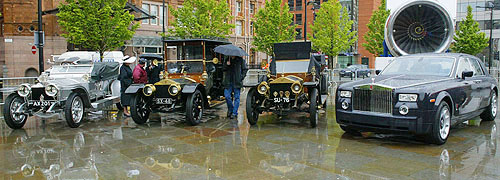  man looks at a line up of Rolls Royce automobiles, including a Silver Ghost and the new ultra-exclusive Rolls Royce Centenary Phantom, made for the 100th anniversary of the founding of the company, in Manchester, England