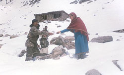 Army personnel provide food to a shepherd family which was trapped on the Pir Panjal ranges of Jammu due to last weeks unseasonal snowfall.