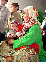 An Afghan woman and her children wait for transport at the UNHCR office in Quetta