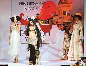 Models carry a chariot as they present creations of designer Kiran Uttam Ghosh at the LIFW in New Delhi