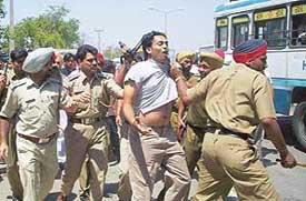 Policemen drag a supporter of the SAD during a mild cane charge on the Kalka-Ambala highway 