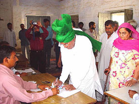 Haryana Chief Minister Om Prakash Chautala accompanied by his wife Sneh Lata, casts his vote at Chautala village in the Sirsa Parliamentary constituency on Monday.