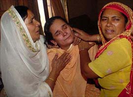 Mourning wife of a SAD leader who was shot in poll-related violence in Sahauli village