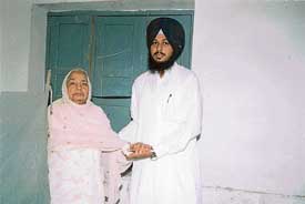 Ms Joginder Kaur, wife of the late Gurcharan Singh Tohra, being escorted by her nephew, Mr Rajinder Singh, to the polling station at Tohra village