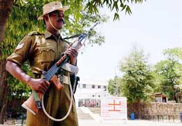 A security personnel stands guard at the entrance of Raisina Bengali School at Gole Market area of New Delhi on Tuesday where the EVMs are kept after the final phase of polling for the Lok Sabha