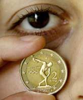 A woman displays a two euro commemorative coin launched to celebrate the return of the Olympic Games to its birthplace in Athens on Wednesday. The coins, depicting a discus thrower, will go into circulation on May 13 and will be a tender throughout the 12 countries sharing the euro.