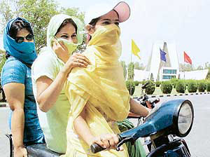 Harsh glare forces these damsels to cover their faces during the highest temperature of 42.3 degree C at Punjabi University in Patiala on Wednesday.