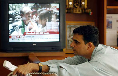 A stockbroker keeps a watch on the latest election updates on TV while trading in a brokerage firm in Mumbai