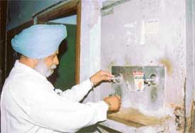 A man drinks water from a cooler installed on the first floor of the Mini Secretariat