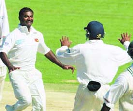 Murali celebrates his new record.