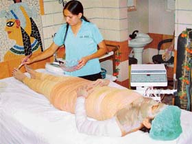 A young girl undergoes a spa treatment with clay body wraps at Cleopatra Day Spa