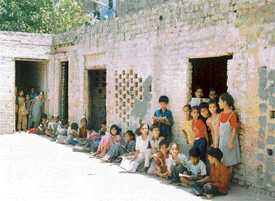 Students of Government Middle School, Field Ganj, sit on a broken floor as they attend class