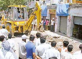 An earth-mover removes encroachments along the Chandigarh-Ambala highway in Zirakpur