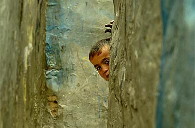A boy peeps from his house during an Israeli raid at the Rafah refugee camp in southern Gaza Strip on Tuesday