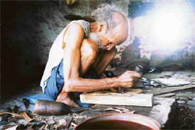 Pahar Singh, who specialises in making Punjabi juttis, busy at work in his shop at Alamgir village