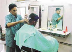 Dharmendras barber, Raj Kumar, at work in his saloon in Chaura Bazar, Ludhiana