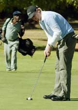 Australian bowler Shane Warne takes a putt during a round of golf in Harare on Wednesday. The Australian cricket team is in Zimbabwe for a cricket tour with the first Test getting under way on Saturday.