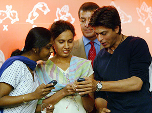 Bollywood actor Shah Rukh Khan checks messages on a mobile phone
