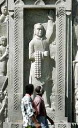 Visitors walk past a granite carving of former Prime Minister Rajiv Gandhi