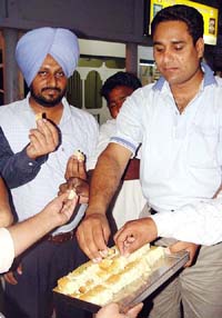 Youth Congress workers distribute sweets on the appointment of Selja as Union Minister at Ambala on Saturday.