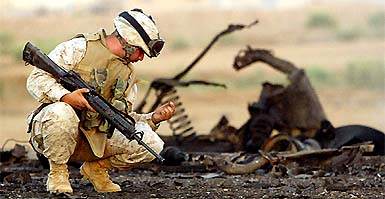 A US marine examines debris after a US military convoy was ambushed near Falluja on Sunday