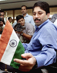 IT and Communication Minister Dayanidhi Maran adjusts the Tricolour on his table after taking charge in New Delhi