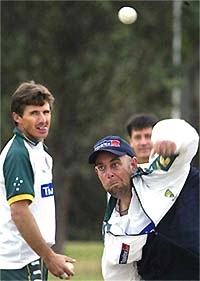 Australian cricketer Darren Lehmann bowls as Brad Hogg looks on during a training session in Harare