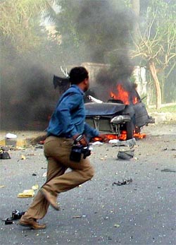 A photographer runs for cover after the second explosion