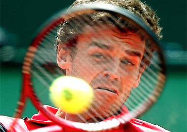 Three-time French Open Champion Gustavo Kuerten of Brazil returns a backhand to Roger Ferderer of Switzerland 