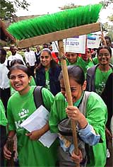 Kenyan schoolgirls of Indian origin march with brooms and posters ahead of World Environment Day-2004 in Nairobi