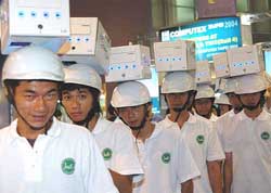 Workers wear computer-shaped hats during the Computex Taipei 2004
