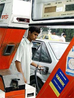 A worker at a petrol station fills a customers car tank in Dhaka, Bangladesh