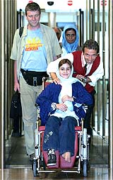 Hiba Kassim, a 14-year-old Iraqi girl who was injured last year by a US cluster bomb, arrives in a wheelchair at Brussels international airport 