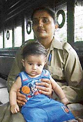 Totas daughter in a policewomans lap before being handed over to her mother at Burail jail in Chandigarh