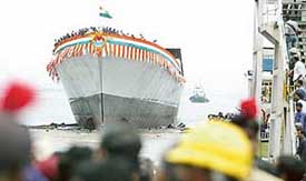 Dock workers watch the launch of Satpura, Indias second indigenously built Stealth Frigate, in Mumbai 