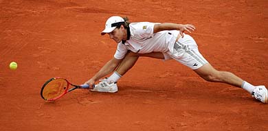 Gaston Gaudio of Argentina stretches to return a forehand during his semifinal against compatriot David Nalbandian at the French Open