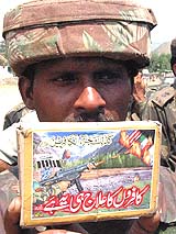 An Army jawan displays anti-India and US literature recovered from slain militants at an Army camp in Mendher, Jammu, on Tuesday.