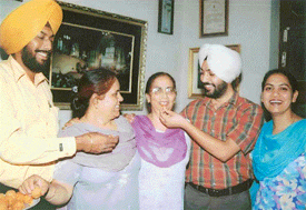 Mrs Inderjit Kaur, wife of Mr Charanjit Singh Atwal, who is tipped to be the Deputy Speaker of the Lok Sabha, being offered ladoos by son Jasjit Singh in Ludhiana