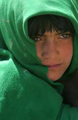 A young Afghan girl waits to receive toys being distributed by the ISAF troops