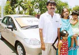 Deepak Monga and his family after being presented a Honda City car in Chandigarh on Thursday.