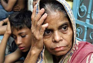Families wait for missing relatives near a collapsed building in the Bangladesh capital Dhaka 