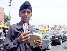 A boy sells his wares at a busy road in Ludhiana